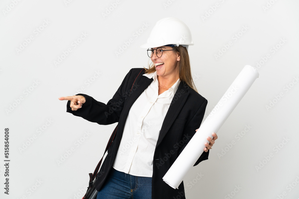 Middle age architect woman with helmet and holding blueprints over isolated background pointing finger to the side and presenting a product Middle age architect woman with helmet and holding blueprints over isolated background pointing finger to the side and presenting a product