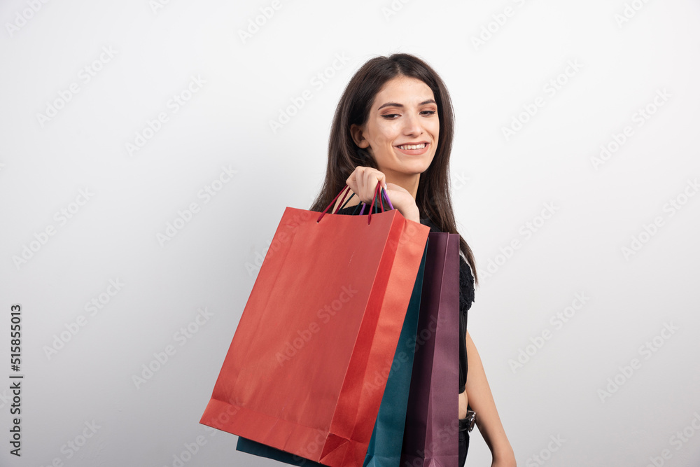 Female model holding shopping bags on white background Female model holding shopping bags on white background