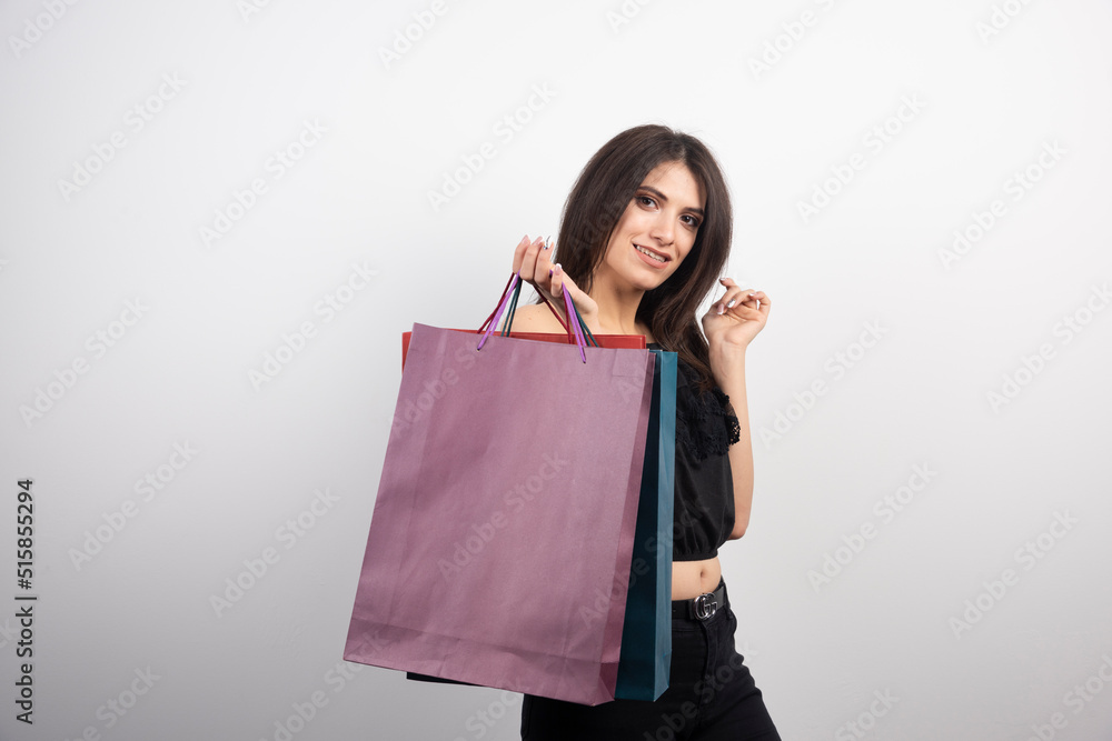 Brunette woman posing with shopping bags on a white background Brunette woman posing with shopping bags on a white background