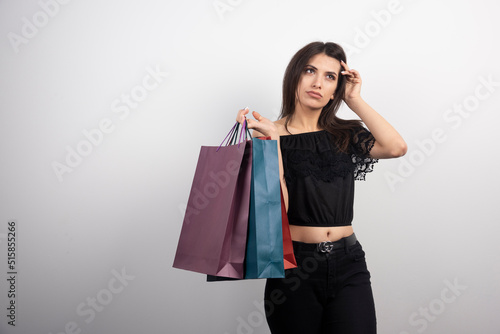 Brunette woman posing with shopping bags on a white background