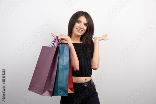 Brunette woman posing with shopping bags on a white background