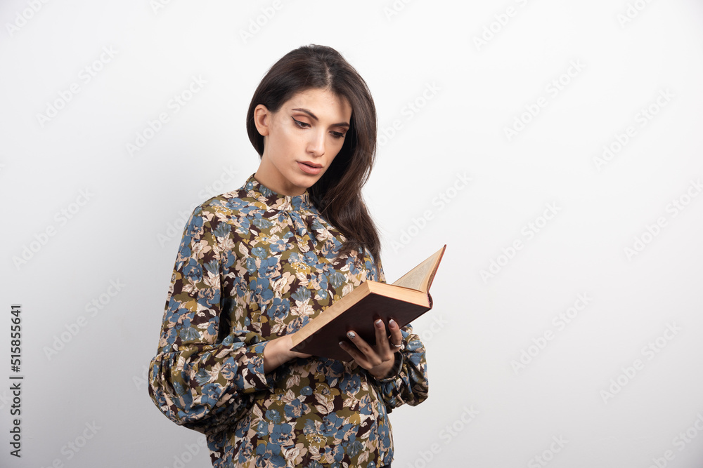 Pretty woman reading a book attentively Pretty woman reading a book attentively