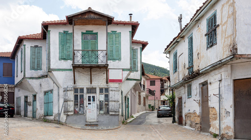 Greece, Arnaia Chalkidiki. Facade of aged two floor building, home and store, covered balcony.