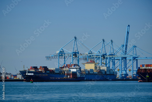 ROTTERDAM, THE NETHERLANDS - New container terminal with a very large container ship and in the foreground a smaller inland container ship on the Maasvlakte of the port of Rotterdam