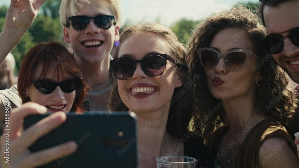 Group of caucasian friends making funny faces for a common selfie on music festival. Shot with RED helium camera in 8K. Group of caucasian friends making funny faces for a common selfie on music festival. Shot with RED helium camera in 8K.