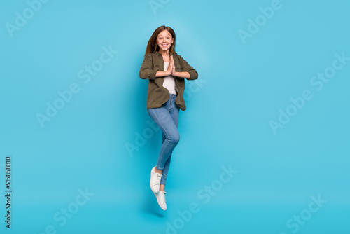 Fototapeta Naklejka Na Ścianę i Meble -  Full size photo of charming brown hair little lady jump traveling hold hands in anticipation isolated on blue color background