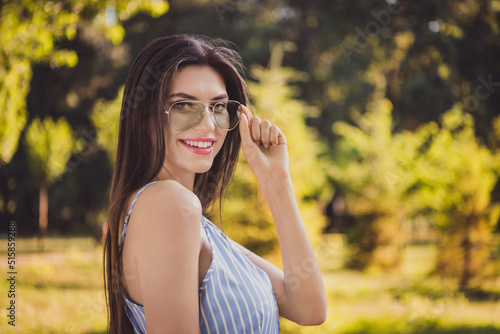 Profile side photo of cute confident charming lady in cool spectacles spend summer vacation outdoors