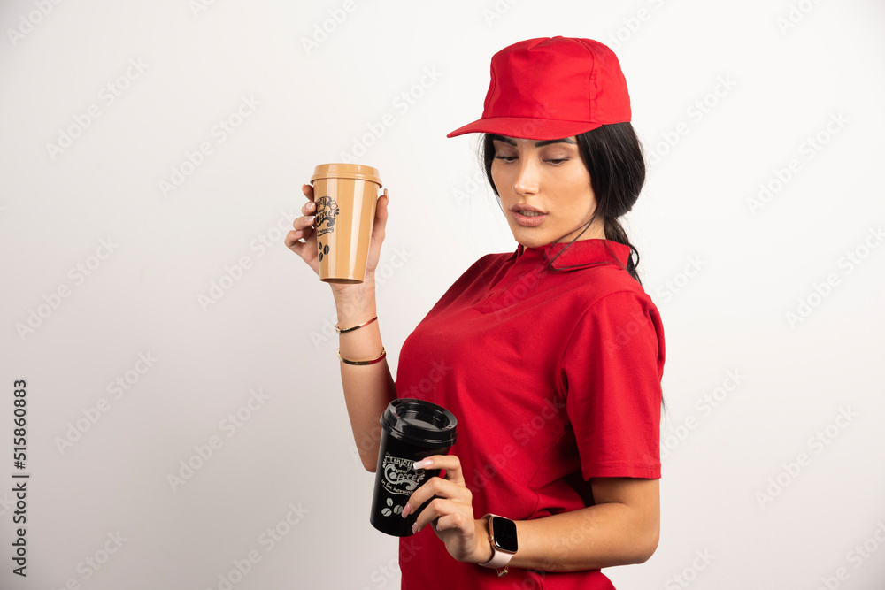 Pretty courier holding coffee cups on white background Pretty courier holding coffee cups on white background