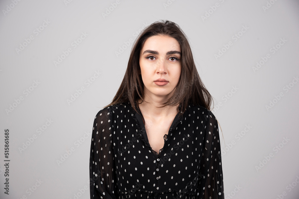 Photo of young serious woman standing and posing Photo of young serious woman standing and posing