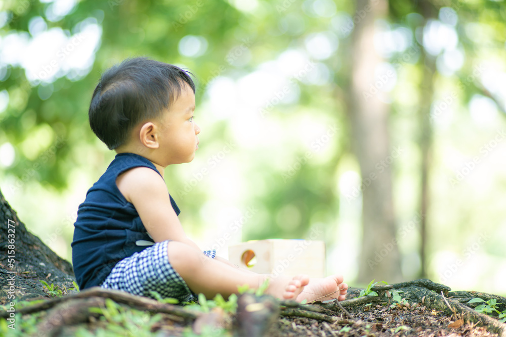 Toddler asian 2 year boy playing on green grass in nature park Toddler asian 2 year boy playing on green grass in nature park
