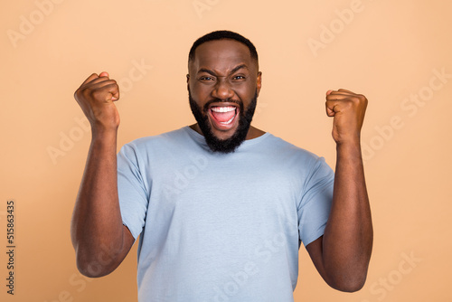 Photo of hooray young beard man yell hands fists wear outfit isolated on beige color background photo
