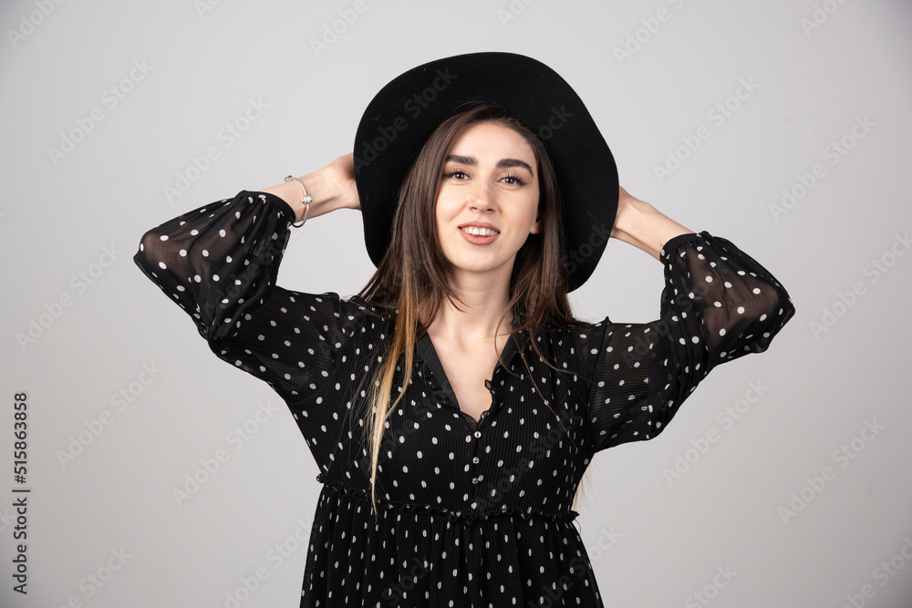 Long haired woman in black dress looking at camera with smiling expression Long haired woman in black dress looking at camera with smiling expression