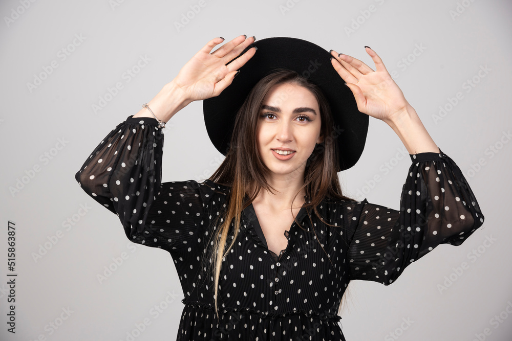 Long haired woman in black dress looking at camera with serious expression Long haired woman in black dress looking at camera with serious expression