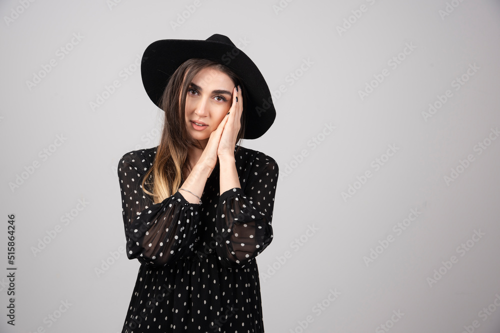 Portrait of woman in black hat holding her face Portrait of woman in black hat holding her face