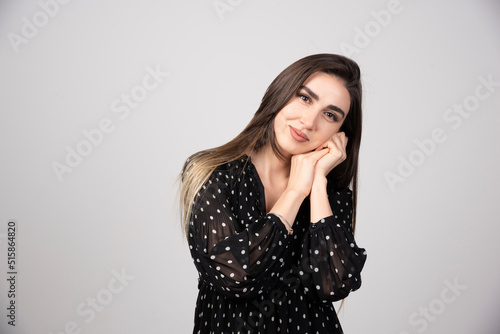 Cute woman in black dress posing to camera