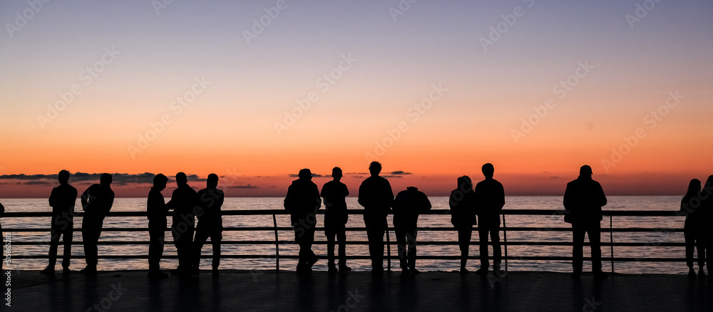 company of people on the beach at sunset.Silhouettes of people at sunset.Beach,sea,relax,evening