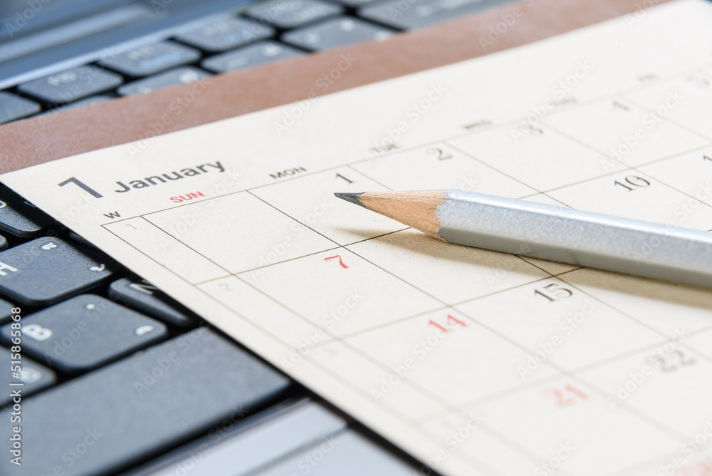 Calendar planner / timetable or schedule arrangement concept : Top view of a silver pencil on a flipped paper / desk calendar. A calendar is a system of organizing days for administrative purposes. Calendar planner / timetable or schedule arrangement concept : Top view of a silver pencil on a flipped paper / desk calendar. A calendar is a system of organizing days for administrative purposes.