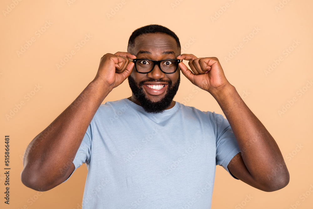 Portrait of attractive cheerful glad smart guy touching specs isolated over beige pastel color background Portrait of attractive cheerful glad smart guy touching specs isolated over beige pastel color background