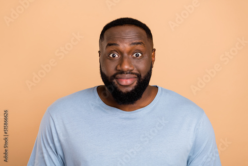 Photo of impressed young beard man look camera wear blue t-shirt isolated on beige color background