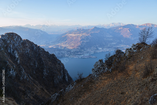 View of Lake Iseo at sunset, with the alps framing it, near the town of Zone, Italy - February 2022.