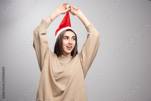 Young woman in Santa's hat posing studio shot isolated on gray © azerbaijan-stockers