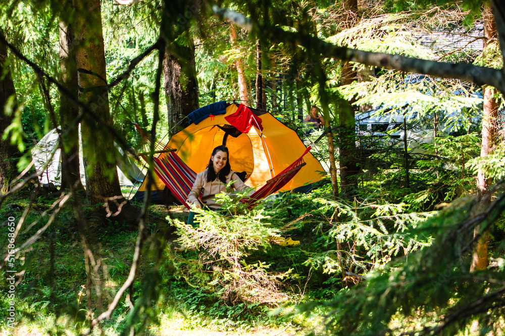 woman laying down in hammock in the forest tent on background