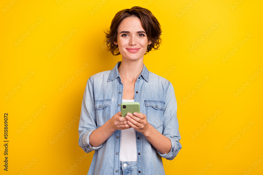 Photo of young pretty woman use smartphone like share post subscribe isolated over yellow color background Photo of young pretty woman use smartphone like share post subscribe isolated over yellow color background