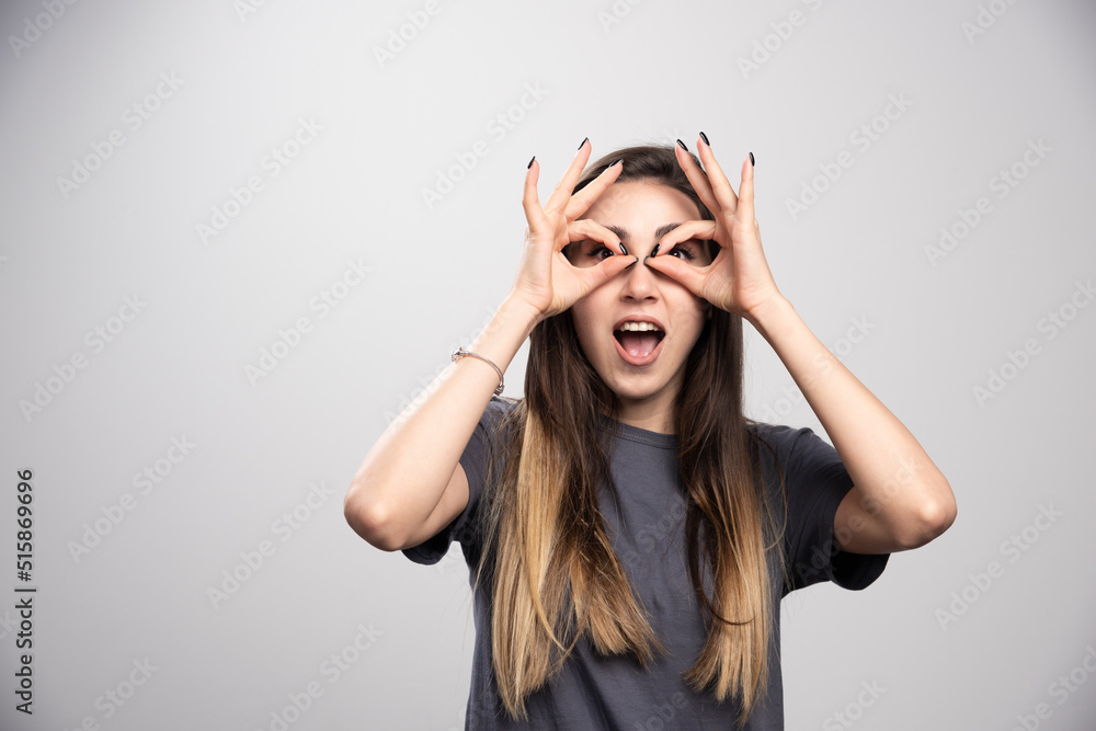 Young woman standing and posing over a gray background Young woman standing and posing over a gray background