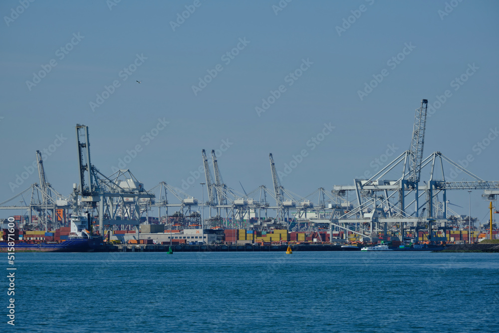 ROTTERDAM, THE NETHERLANDS - New container terminal with a very large container ship and in the foreground a smaller inland container ship on the Maasvlakte of the port of Rotterdam