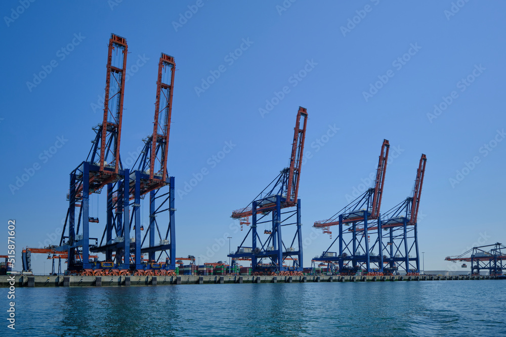 Obraz premium ROTTERDAM, THE NETHERLANDS - New container terminal with a very large container ship and in the foreground a smaller inland container ship on the Maasvlakte of the port of Rotterdam