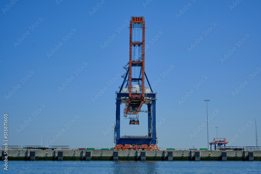 Fototapeta premium ROTTERDAM, THE NETHERLANDS - New container terminal with a very large container ship and in the foreground a smaller inland container ship on the Maasvlakte of the port of Rotterdam