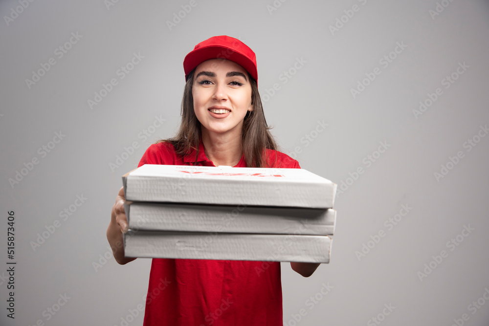 Delivery woman giving away from pizza orders Delivery woman giving away from pizza orders