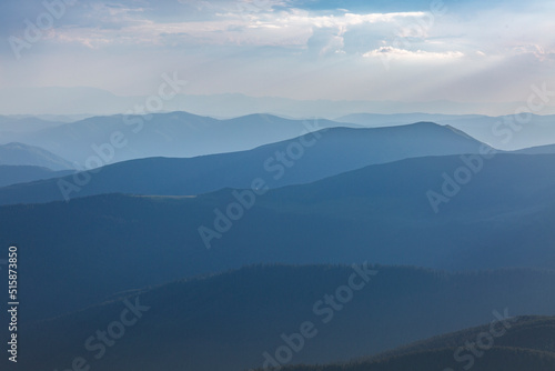 Panoranic blue view of mountain hills and meadows during sunset © almostfuture