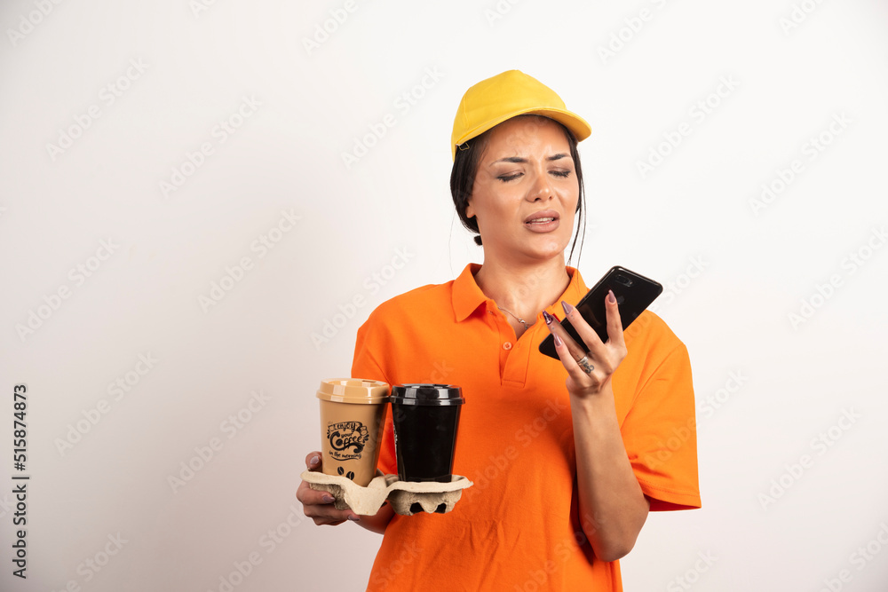 Upset woman with cups looking on smartphone Upset woman with cups looking on smartphone