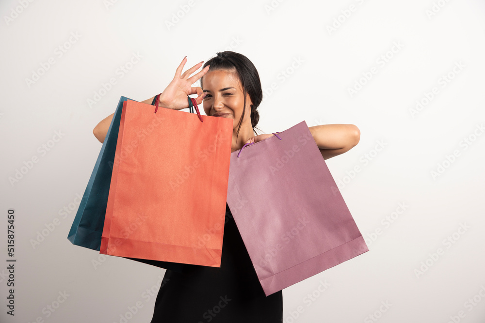 Happy woman showing shopping bags on white background Happy woman showing shopping bags on white background
