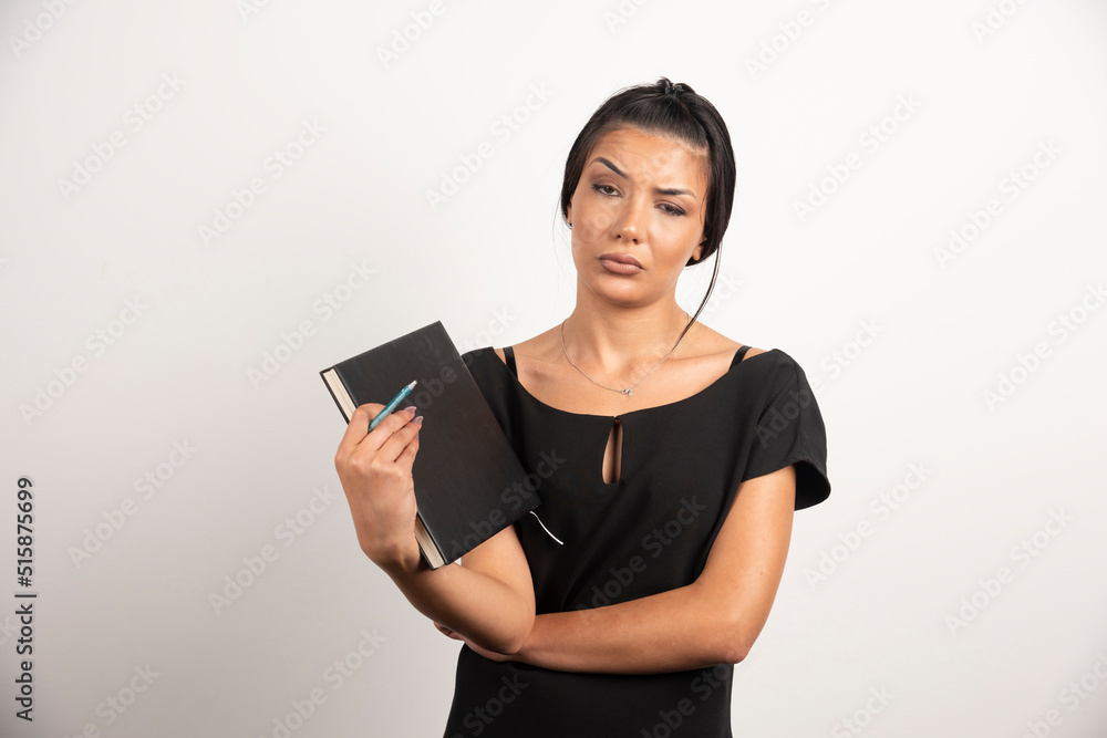 Thoughtful businesswoman posing with notebook on white background Thoughtful businesswoman posing with notebook on white background