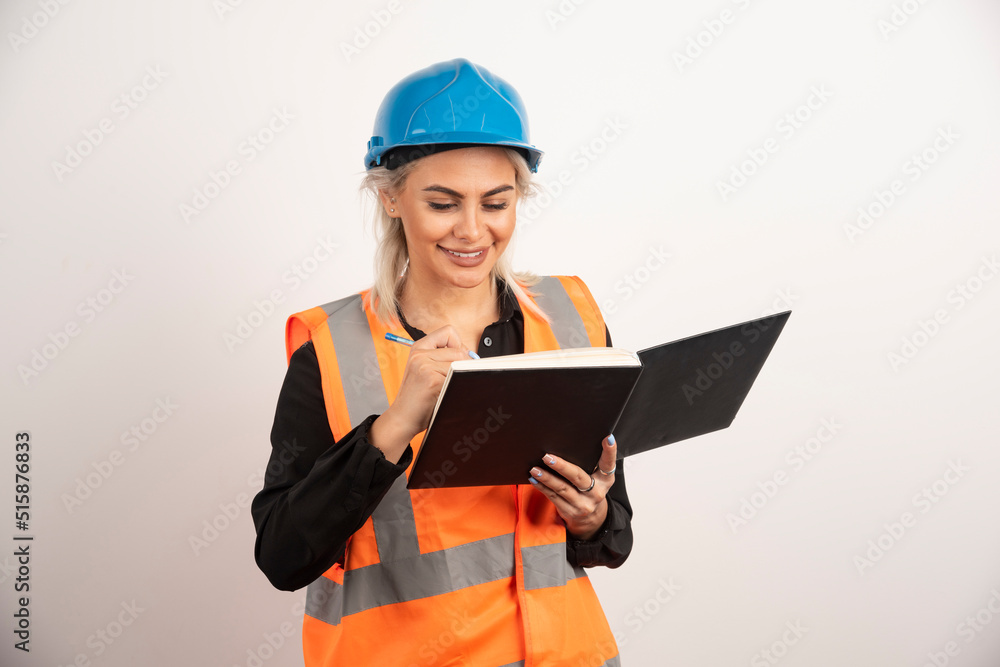 Positive construction worker writing in notebook Positive construction worker writing in notebook