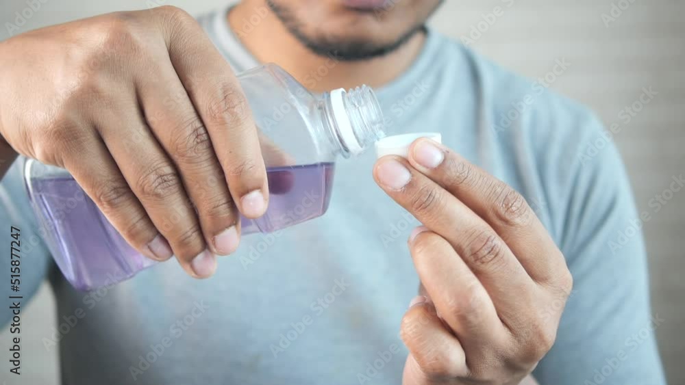 mouthwash liquid flowing into a cap mouthwash liquid flowing into a cap