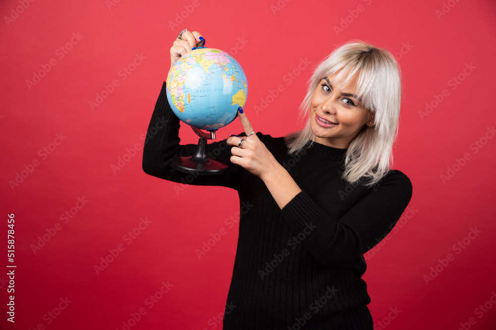 Portrait of woman holding an Earth globe on a red background Portrait of woman holding an Earth globe on a red background