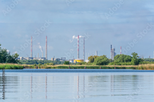 Fuming chimneys of the chemical plant at Police over the calm water of Szczecin Bay.