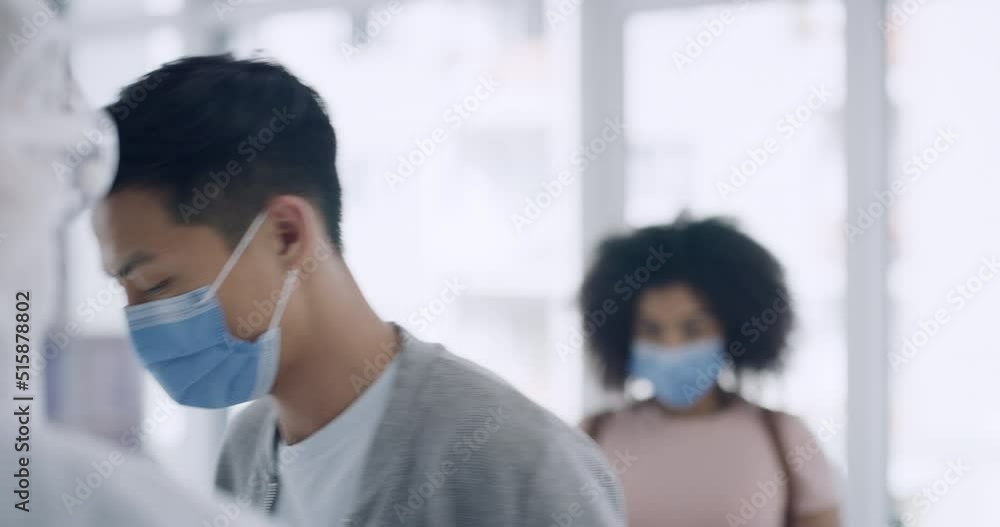 A doctor using a thermometer to measure a patients temperature in cover testing center. A man and woman wearing masks and getting scanned for corona virus or monkeypox symptoms A doctor using a thermometer to measure a patients temperature in cover testing center. A man and woman wearing masks and getting scanned for corona virus or monkeypox symptoms