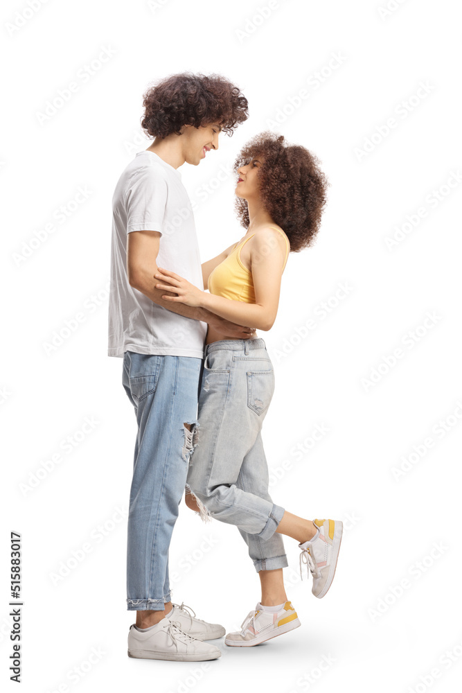 Full length profile shot of casual young couple in love hugging and looking at each other Full length profile shot of casual young couple in love hugging and looking at each other