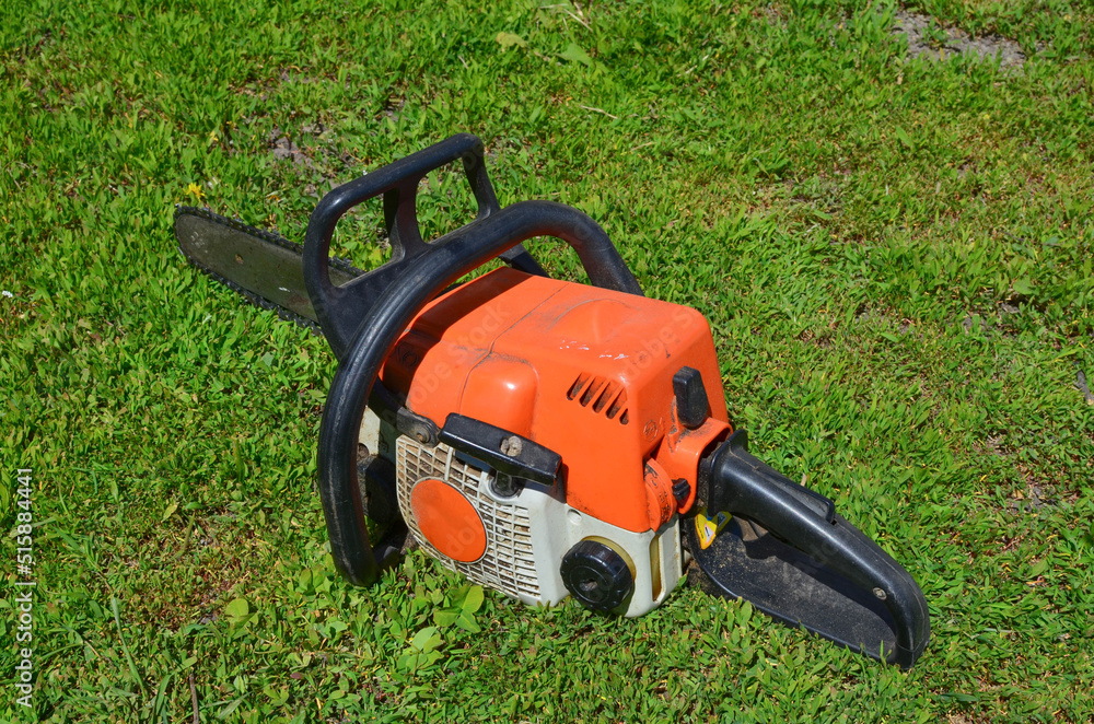 an old chainsaw on the green grass