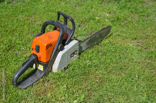 an old chainsaw on the green grass