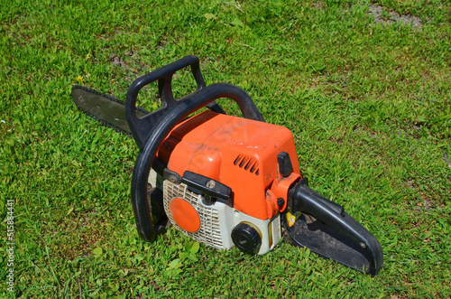 an old chainsaw on the green grass