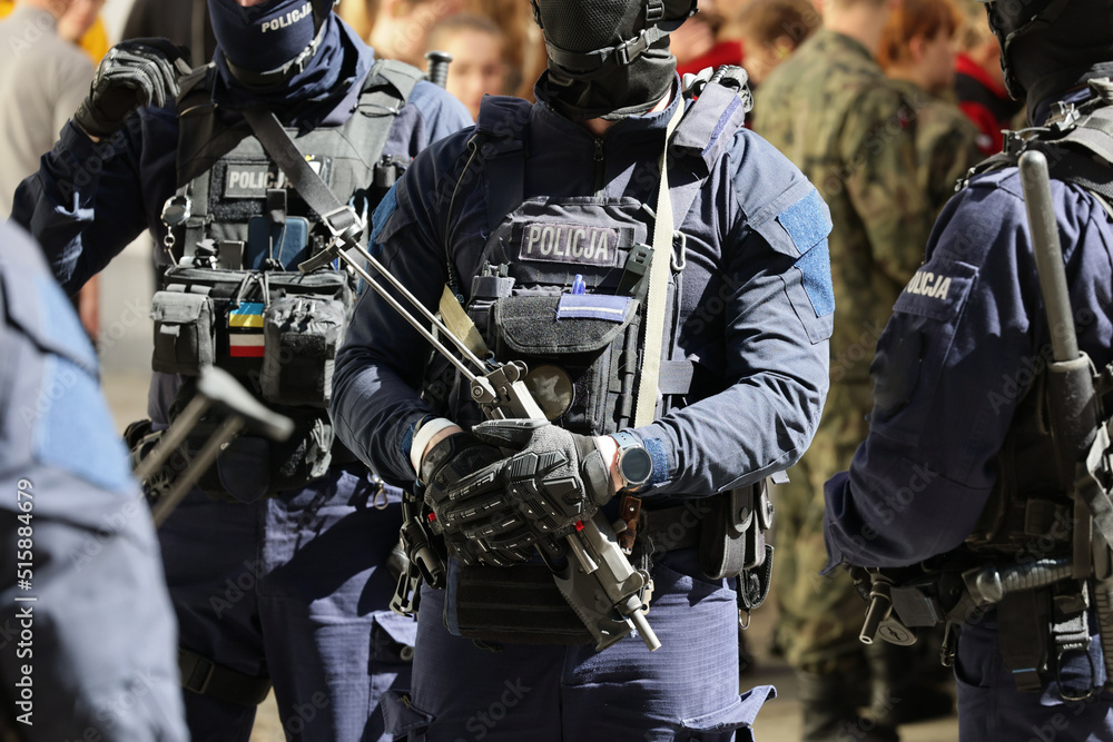 Policjant w niebieskim mundurze uzbrojony w pistolet maszynowy w czasie ćwiczeń.  - obrazy, fototapety, plakaty 