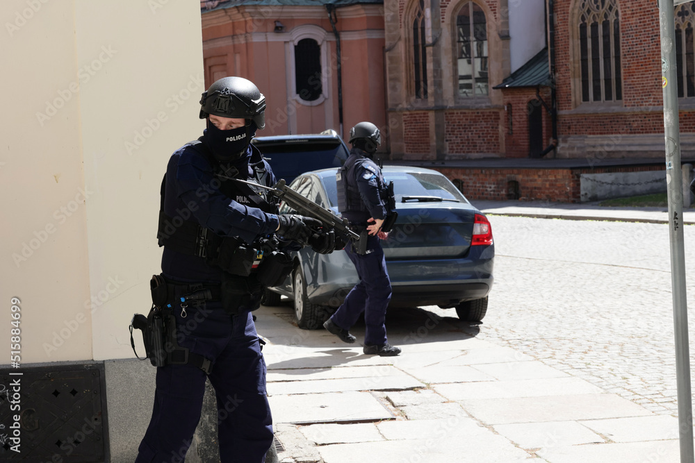 Policjant w niebieskim mundurze uzbrojony w pistolet maszynowy w czasie ćwiczeń.  - obrazy, fototapety, plakaty 