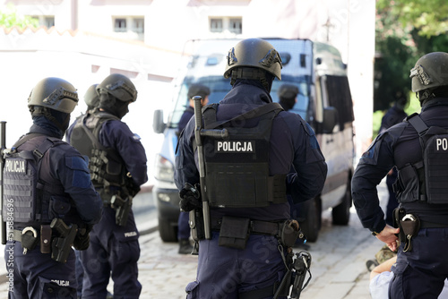 Policjant w niebieskim mundurze uzbrojony w pistolet maszynowy w czasie ćwiczeń. 