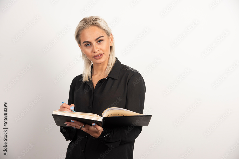 Young woman posing with a pencil and clipboard on white background Young woman posing with a pencil and clipboard on white background