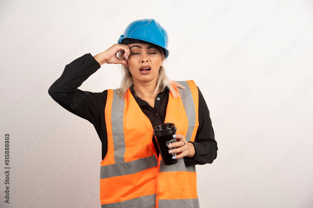 Construction worker with cup of tea feeling sleepy